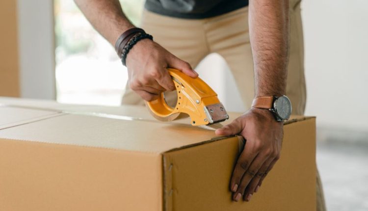 Homme qui ferme un carton